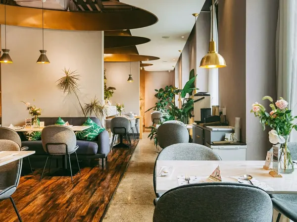 The hotel restaurant with green chairs and pendant lights