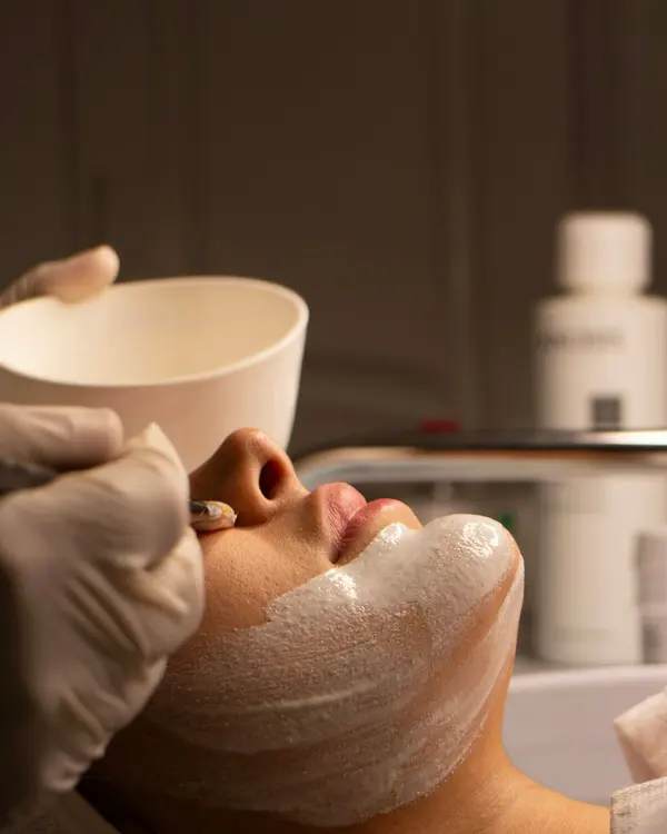 A client relaxing during a facial with a face mask