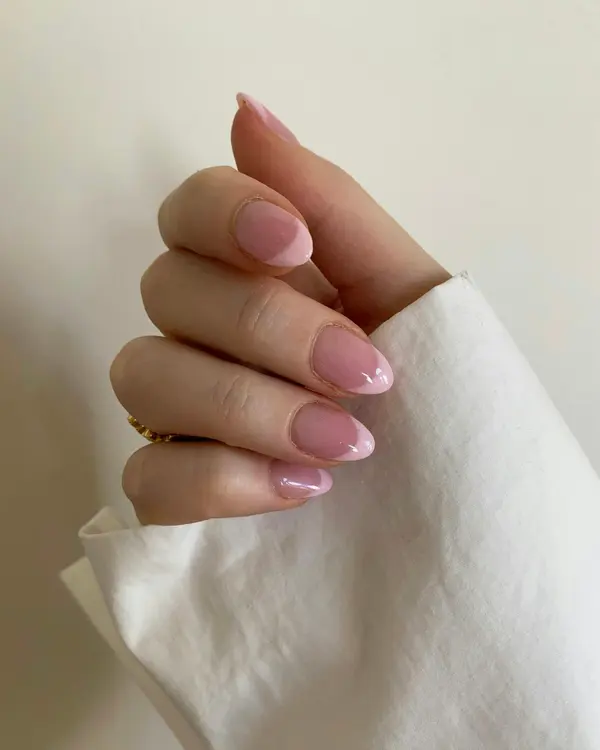 Hands with blush pink gel nails and gold accents