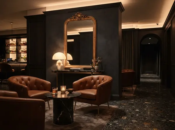 Hotel lounge with charcoal walls, a gilded mirror and cognac leather armchairs