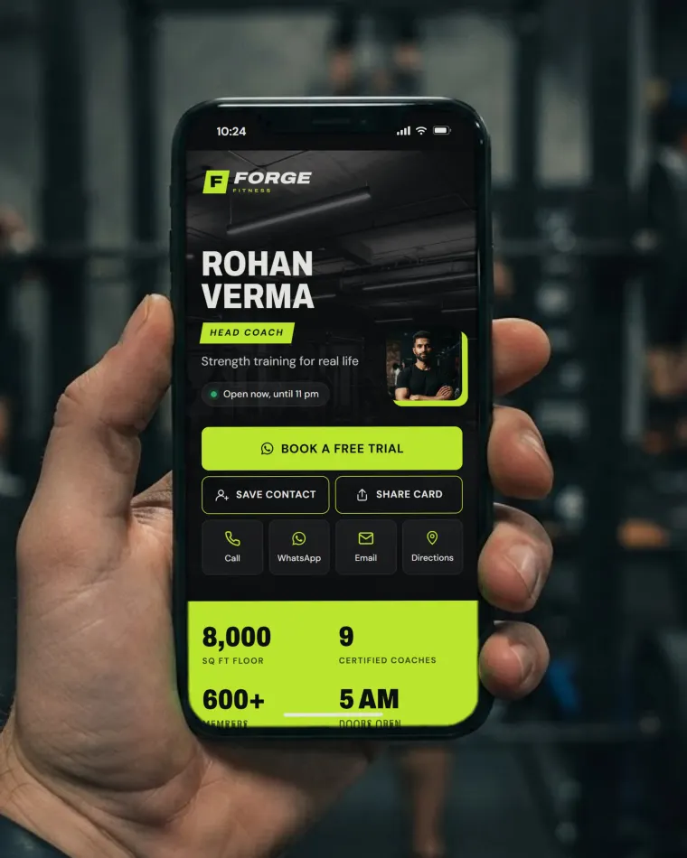 Phone in a gym showing the Forge Fitness web card in black and lime: the gym logo, the head coach’s photo, contact buttons and Save contact